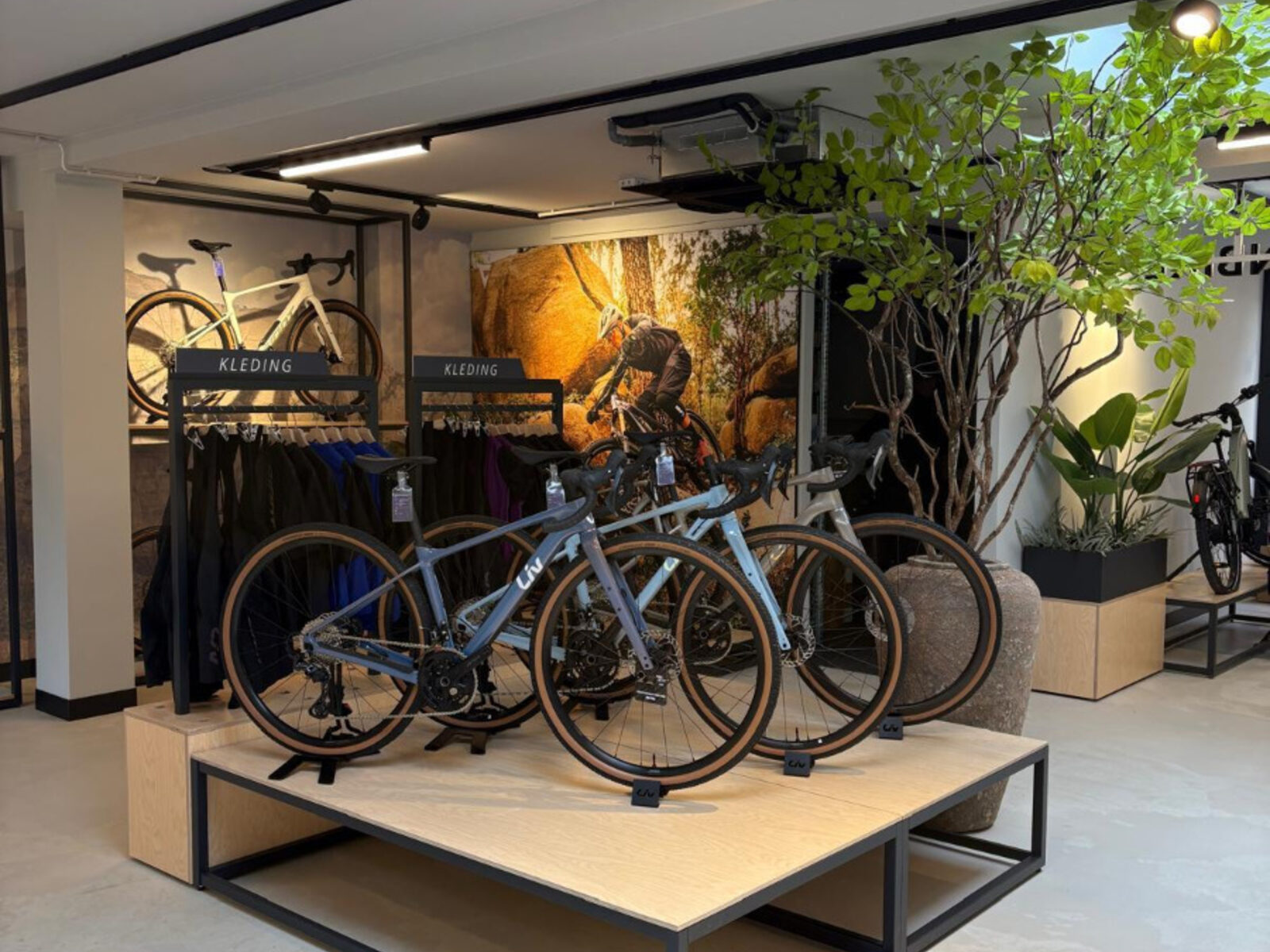 Podiumpresentatie met Liv-fietsen en kledingrekken