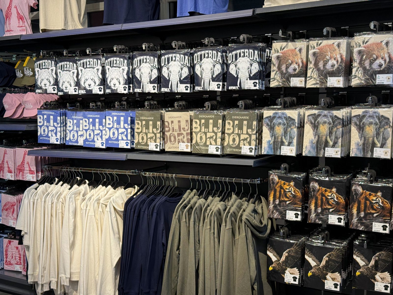 Kledingwand met ingelijste dierenprints, petten en hangpresentatie