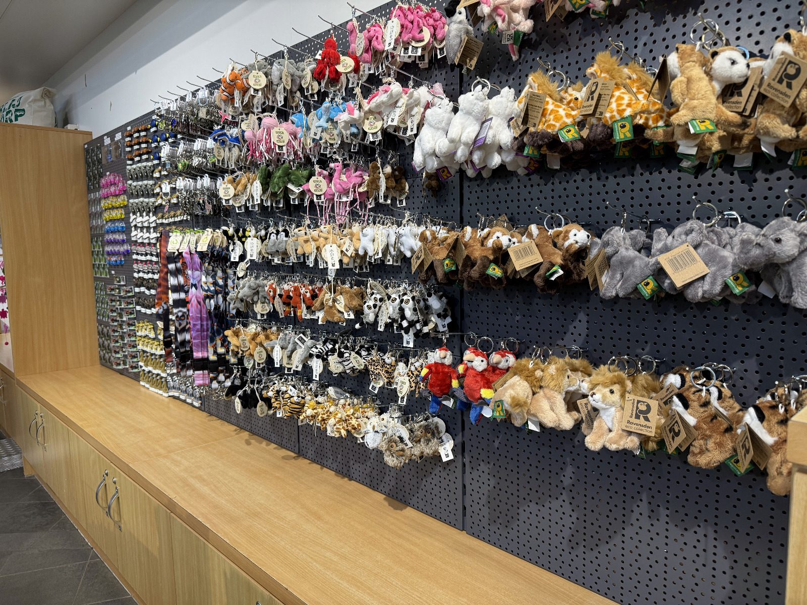 Presentatiewand met sleutelhangers en kleine souvenirs op verstelbare haken